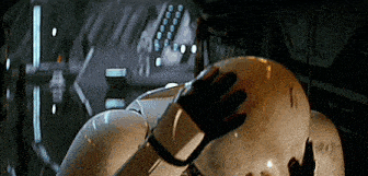 a close up of a person 's hand touching a robot 's helmet in a dark room . a close up of a person 's hand touching a robot 's helmet in a dark room .