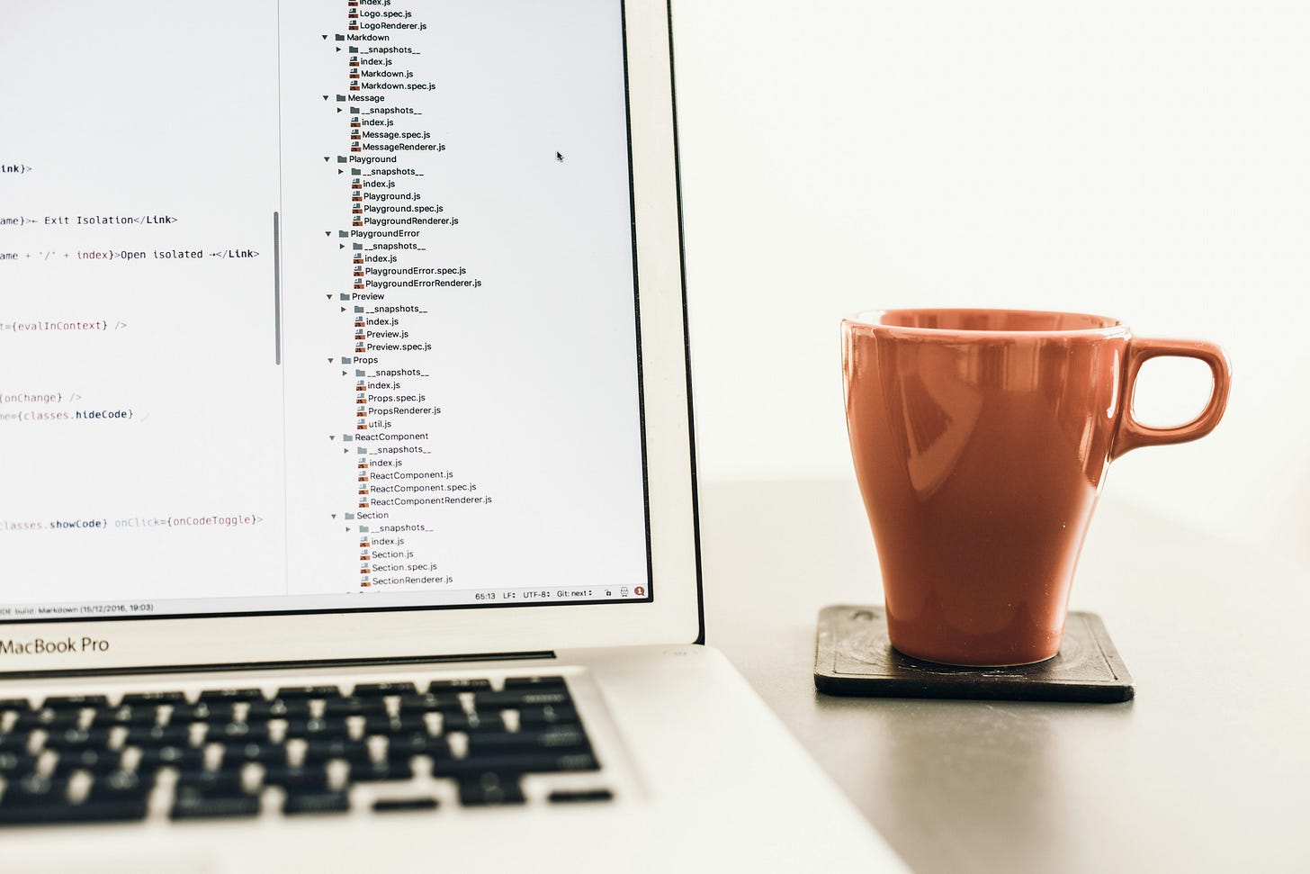 Laptop showing React code, and a coffee mug. Laptop showing React code, and a coffee mug.