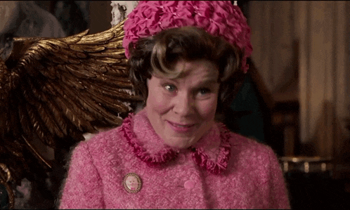 Gif of Dolores Umbridge from Harry Potter smiling smugly. Gif of Dolores Umbridge from Harry Potter smiling smugly.