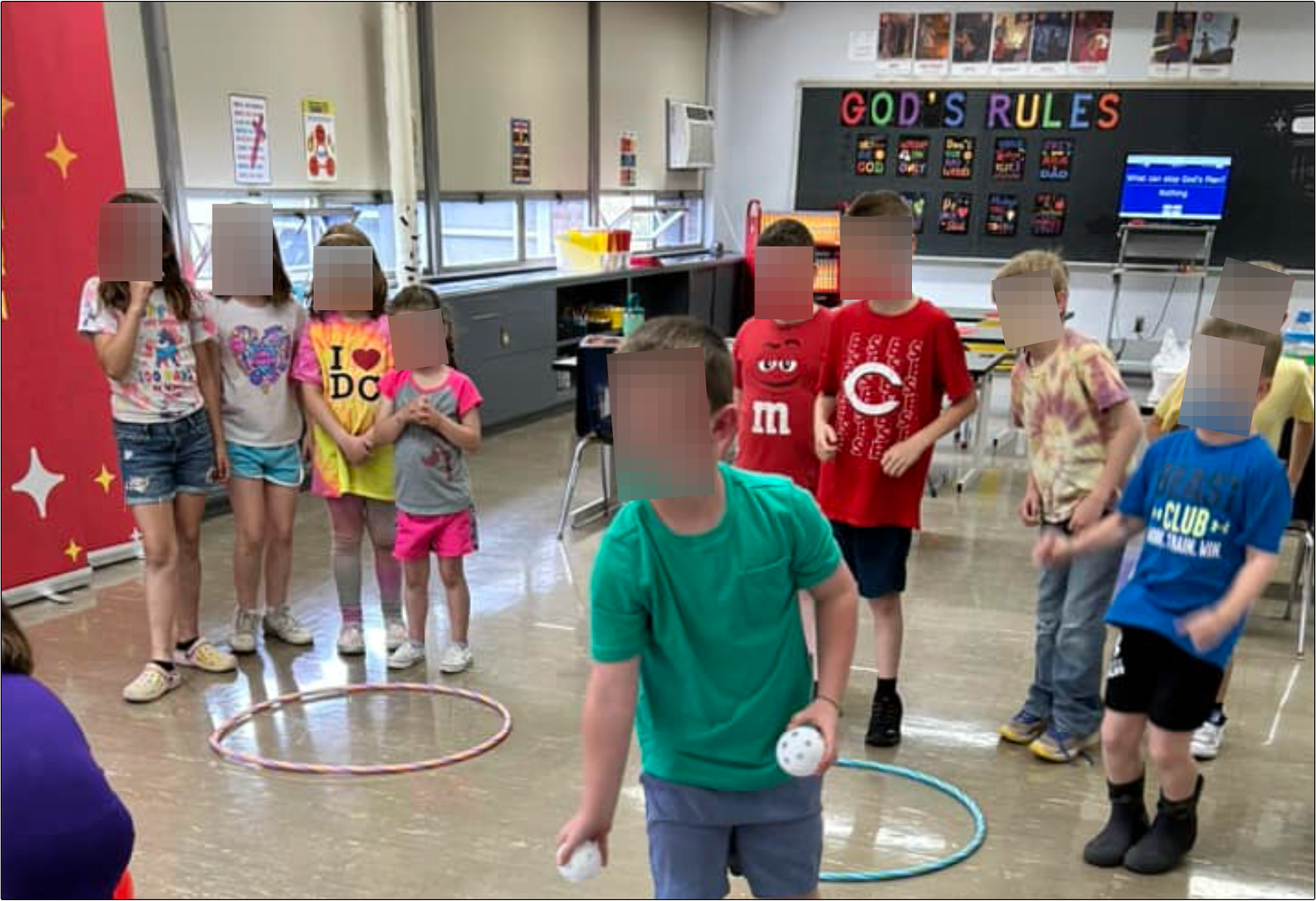 LifeWise Elmwood students on public school property at Elmwood Local School District for Bible study playing a game, "God's Rules" is displayed on the chalkboard.
