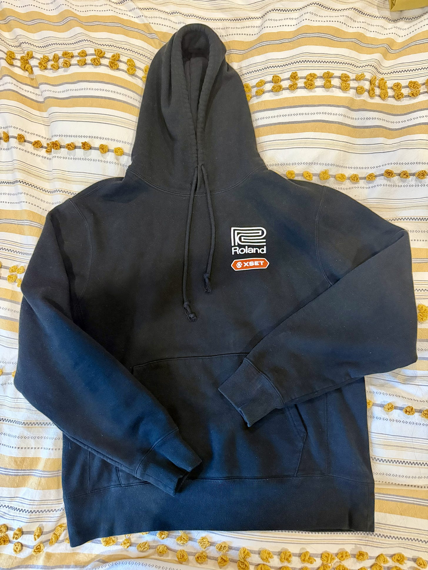 A faded black hoodie sweatshirt with a music-gear logo A faded black hoodie sweatshirt with a music-gear logo