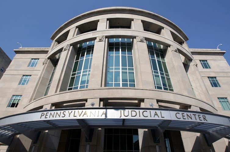Exterior of grey concrete building with sign that says 'Pennsylvania Judicial Center'