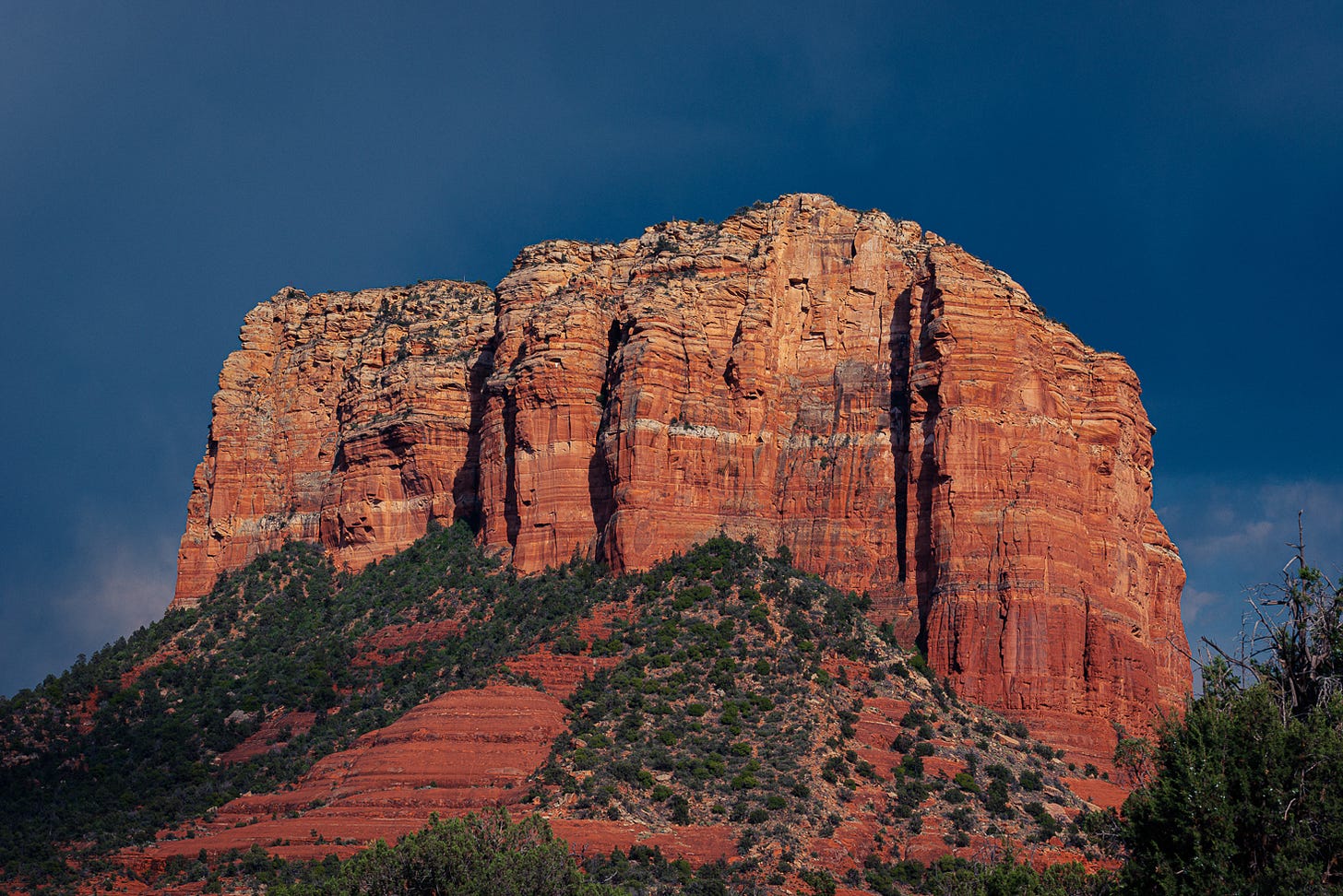 Dark blue storm clouds behind a red rock formation.