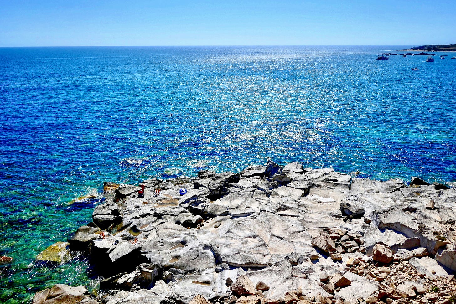 propaggie rocciosa dell'isola di Carloforte che si protente nel mare azzurro, con l'orizzonte sullo sfondo propaggie rocciosa dell'isola di Carloforte che si protente nel mare azzurro, con l'orizzonte sullo sfondo