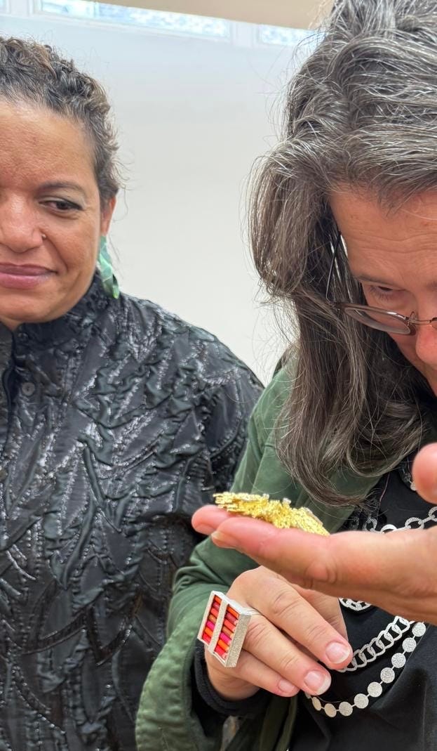 Melanie Grant, Jo McAllister looking at back of GRIMA gold and diamond brooch and pendant