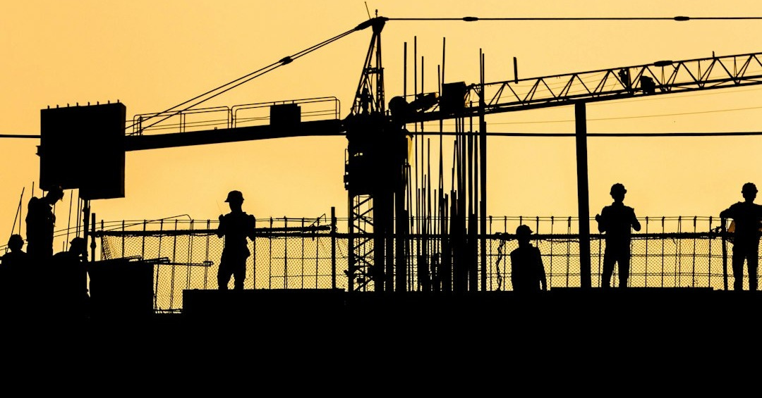 silhouette of people standing on tower crane during night time