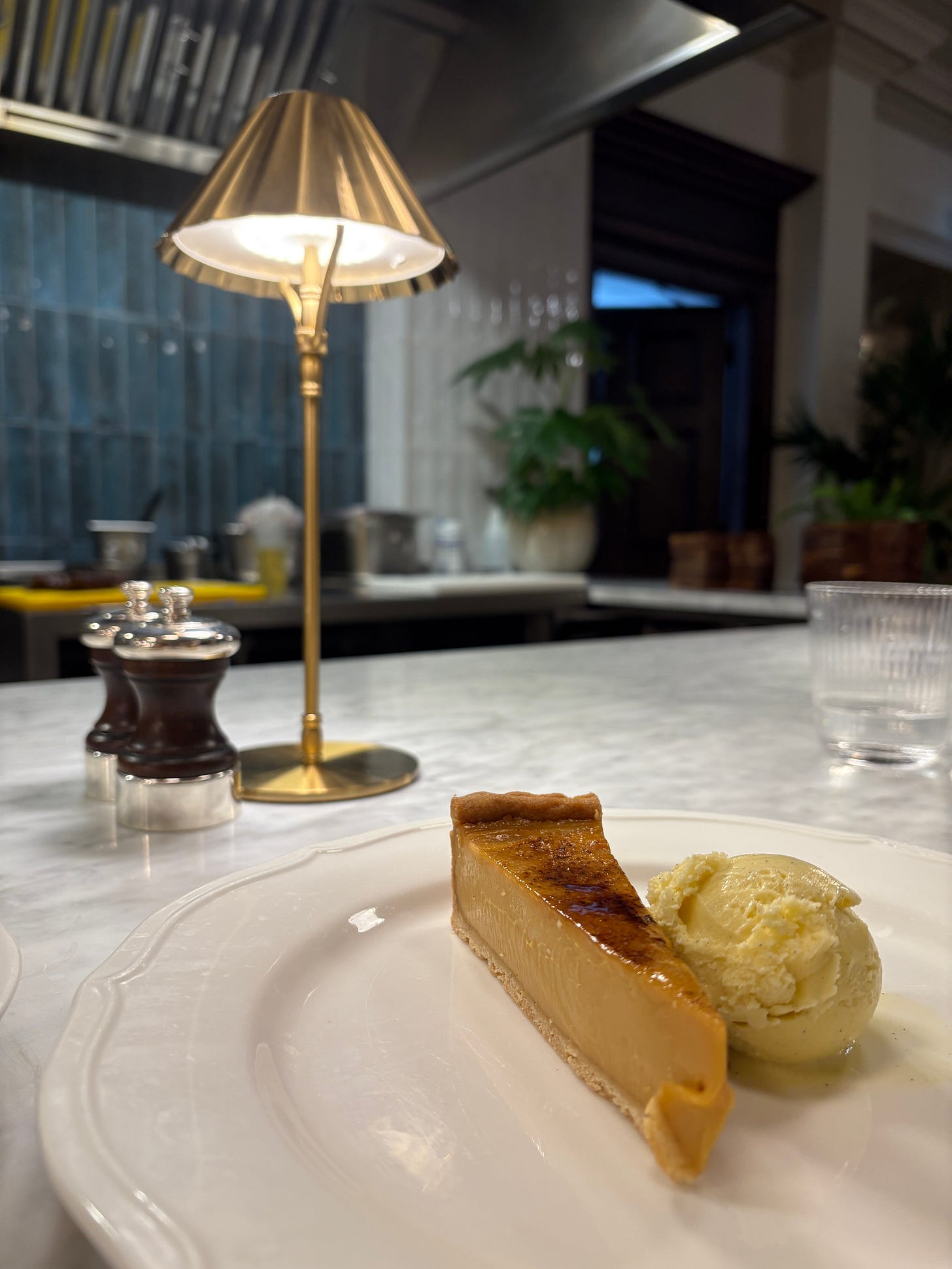 A just-set slice of miso custard tart adorns a plate under a table lamp A just-set slice of miso custard tart adorns a plate under a table lamp