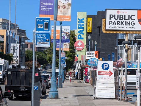 1: Wide street with a large parking garage, 2: Wide 4 lane Beach Street. Multi-level parking  garage on the right, 3: A zoomed photo of the street showing 5 parking signs.