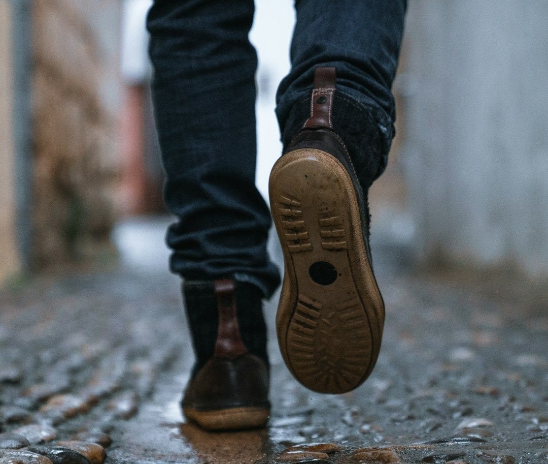 close-up photography of person walking on pavement close-up photography of person walking on pavement