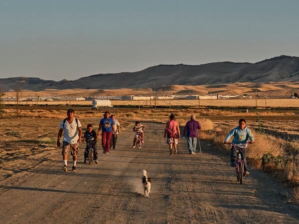 People walking and biking on an unpaved road.