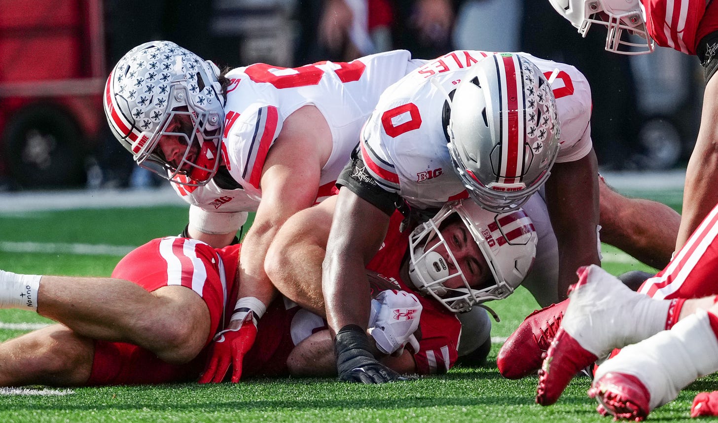 Wisconsin Badgers running back Cade Yacamelli is brought down by Ohio State defenders during a home game at Camp Randall Stadium. Wisconsin Badgers running back Cade Yacamelli is brought down by Ohio State defenders during a home game at Camp Randall Stadium.