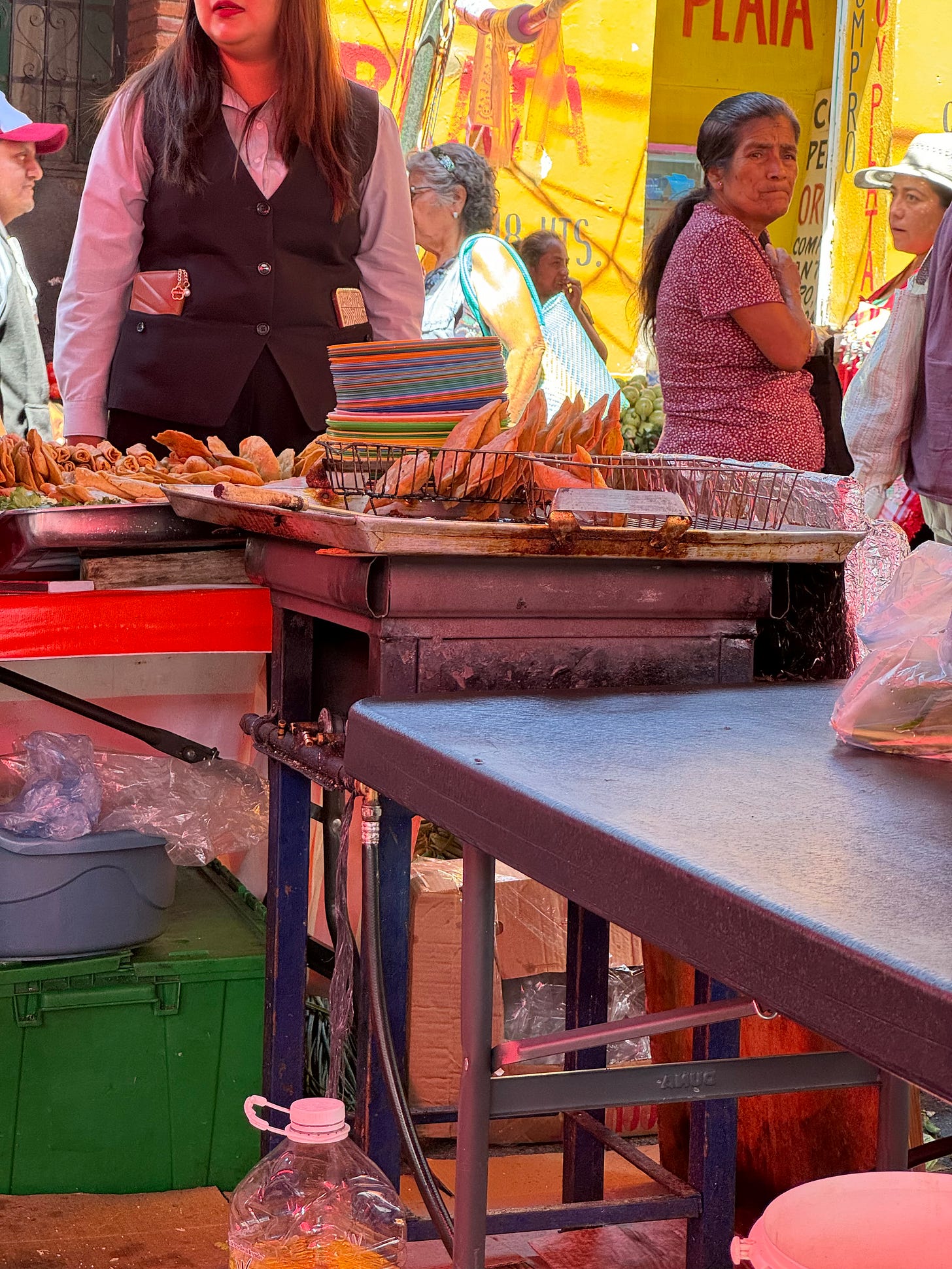 Fried food sitting on a draining rack at a food stand in a market.