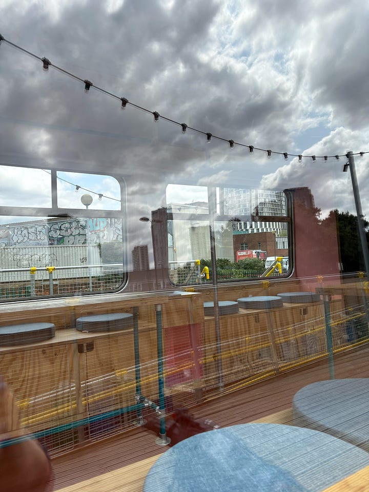 Different perspectives of the cafe inside an old railway carriage. There is a big wooden terrace.