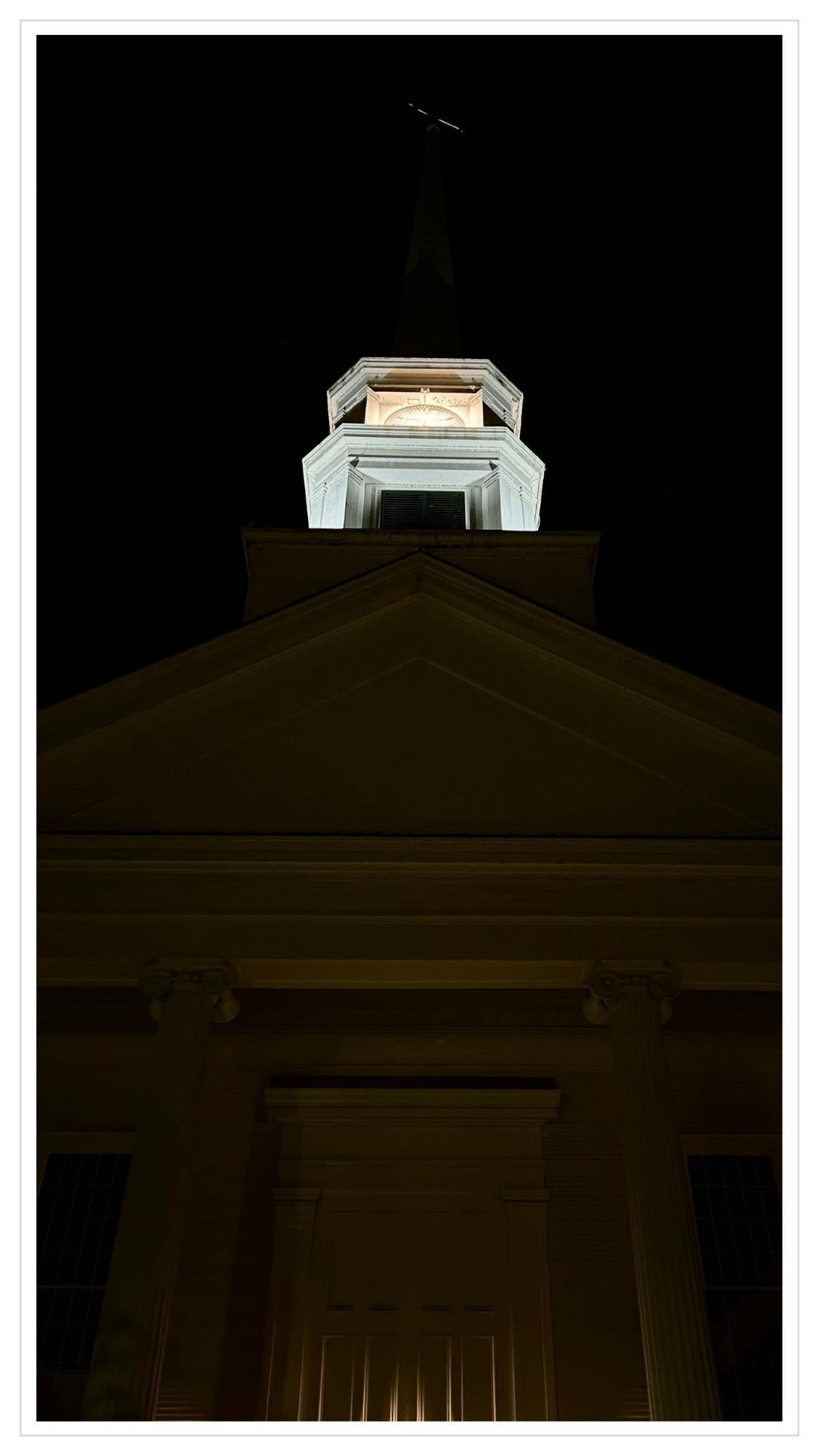 Nightime: historic church steeple & bell tower illuminated from above and below