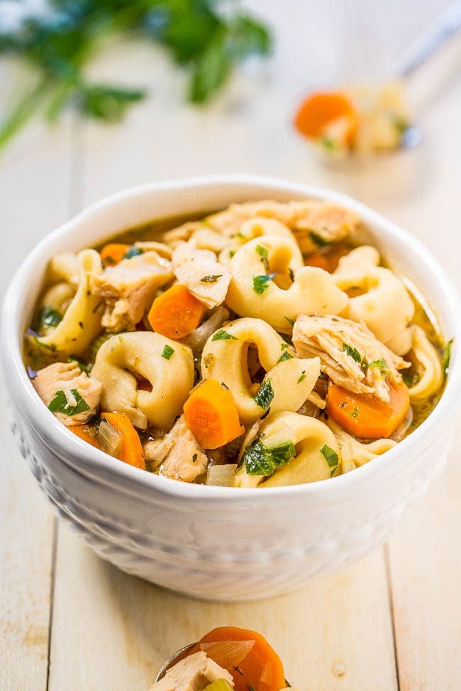 A bowl of chicken noodle soup with tortellini. A bowl of chicken noodle soup with tortellini.