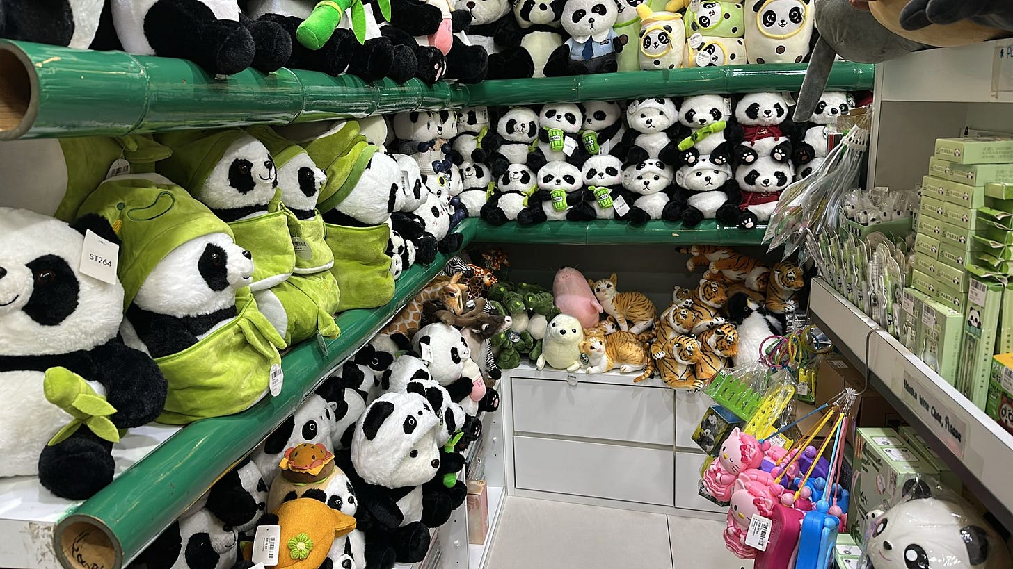 A photo of part of the gift shop in KL zoo, showing several rows of panda toys.