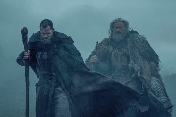 This image released by A24 shows Bill Skarsgård, left, and Hugh Jackman in a scene from "The Death of Robin Hood." (Aidan Monaghan/A24 via AP)