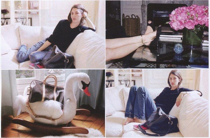 This may contain: a woman sitting on top of a white couch next to a swan shaped chair and holding a purse This may contain: a woman sitting on top of a white couch next to a swan shaped chair and holding a purse