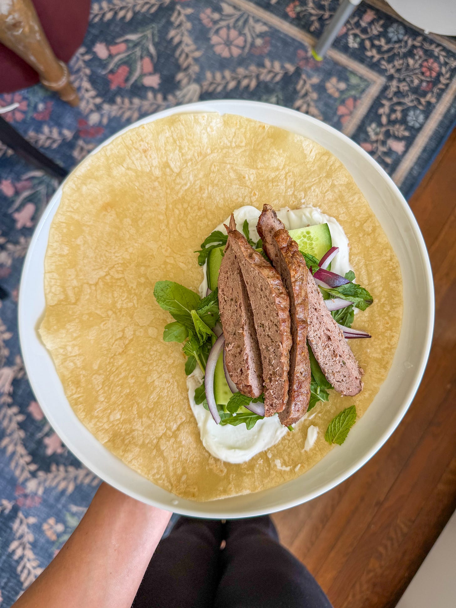 Soft tortilla wrap filled with lamb, yogurt sauce, and fresh greens Soft tortilla wrap filled with lamb, yogurt sauce, and fresh greens