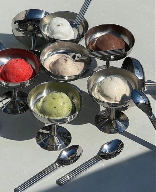 This may contain: an array of spoons and bowls with ice cream in them on a white surface