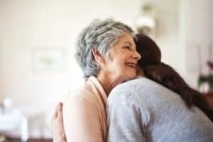 senior woman hugging a younger woman