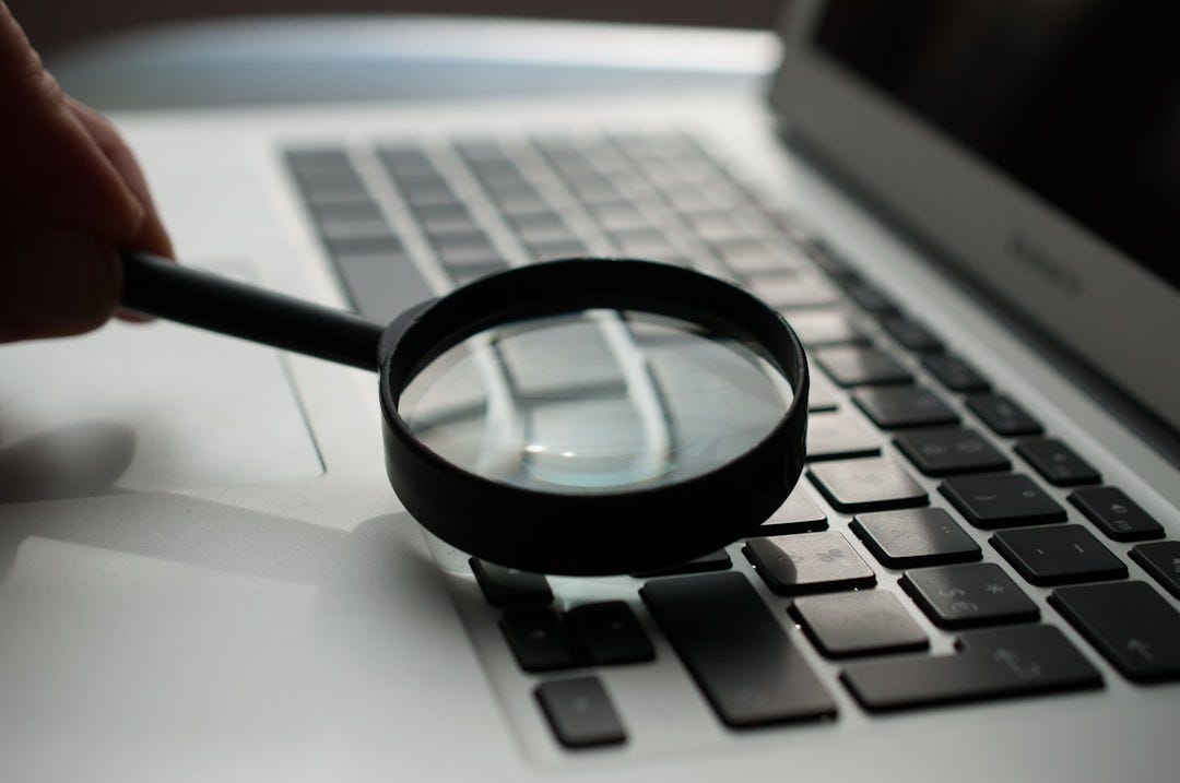 magnifying glass near gray laptop computer magnifying glass near gray laptop computer