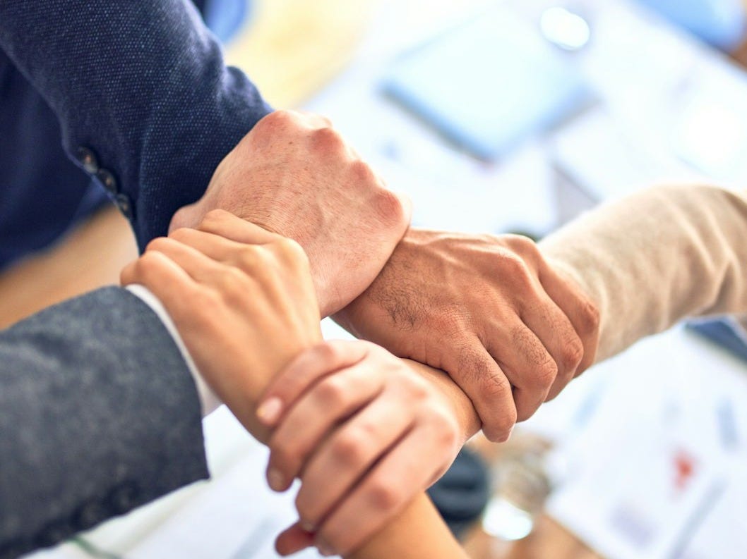person in black long sleeve shirt holding persons hand