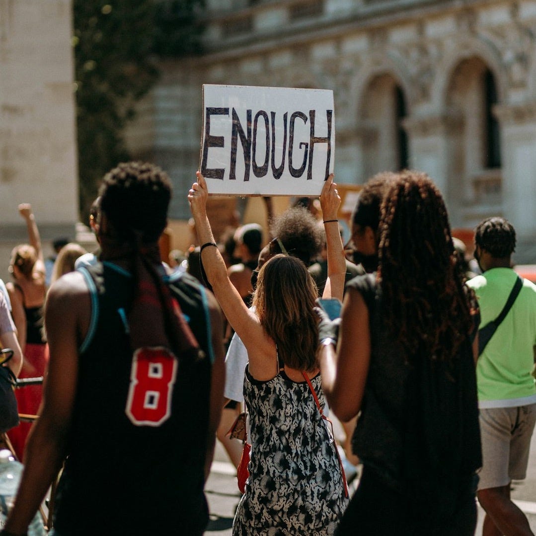 people holding a signage during daytime