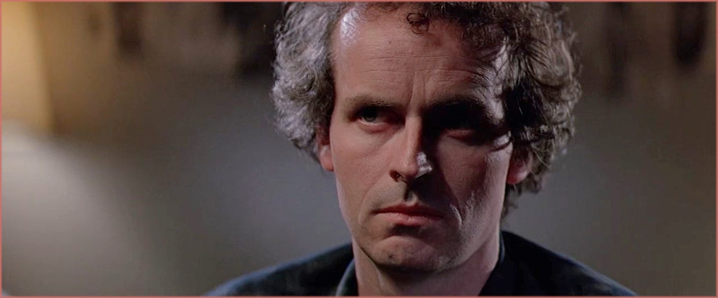Close-up from The Thing (1982): Palmer (David Clennon) with his eyes almost entirely in shadow, no visible eye light reflection in his pupils. Dean Cundey, ASC has confirmed this was a deliberate choice to signal the character's non-human nature before the blood test sequence.