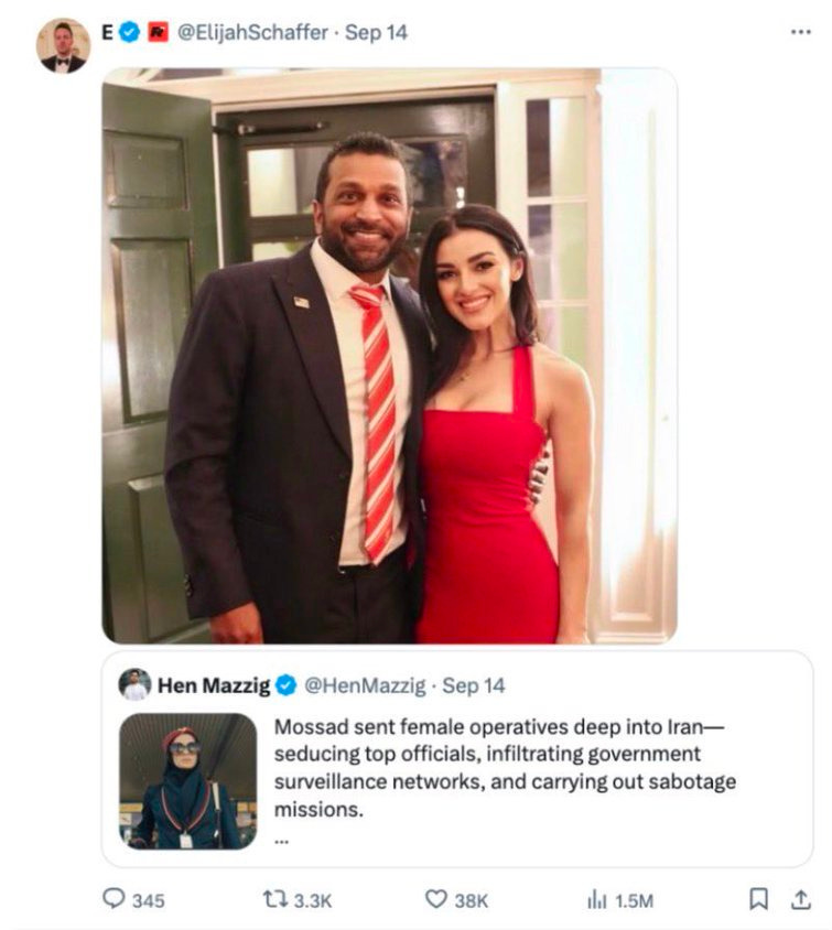 A man with a beard wearing a dark suit and red tie stands next to a woman in a red sleeveless dress both smiling and posing professionally in front of a wooden door with glass panels the image is from a quoted tweet by Hen Mazzig discussing female agents.