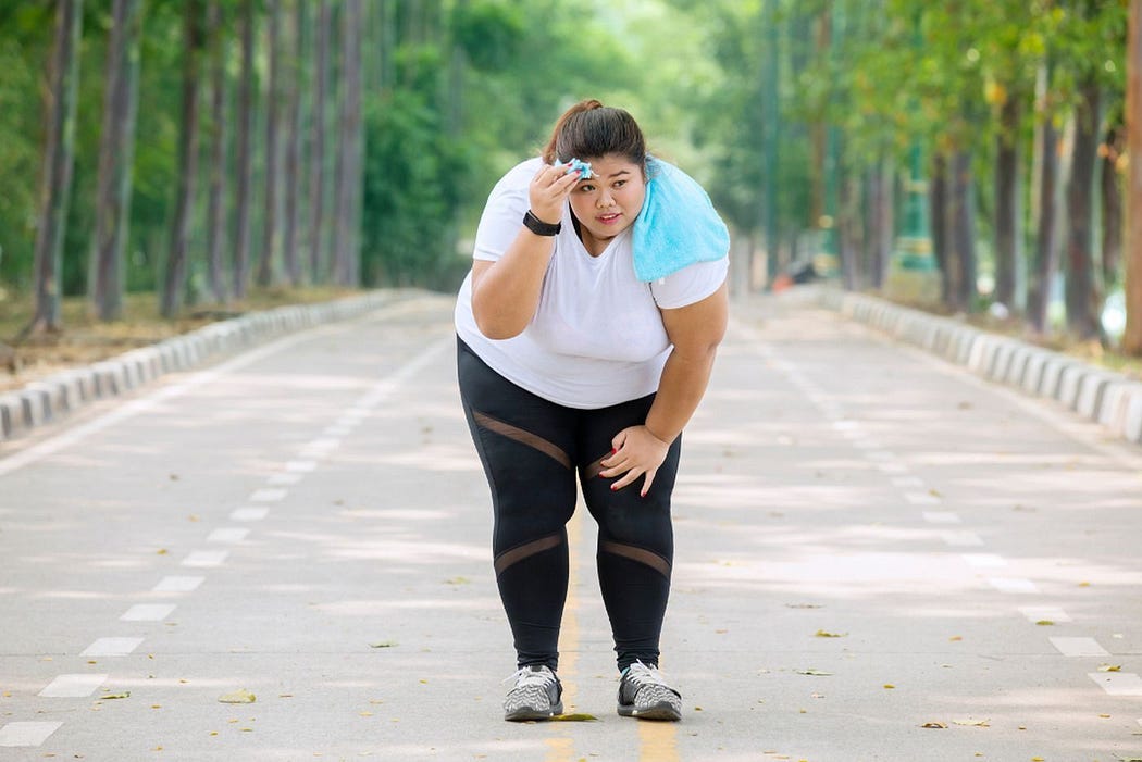 Overweight Asian taking a break from exercise