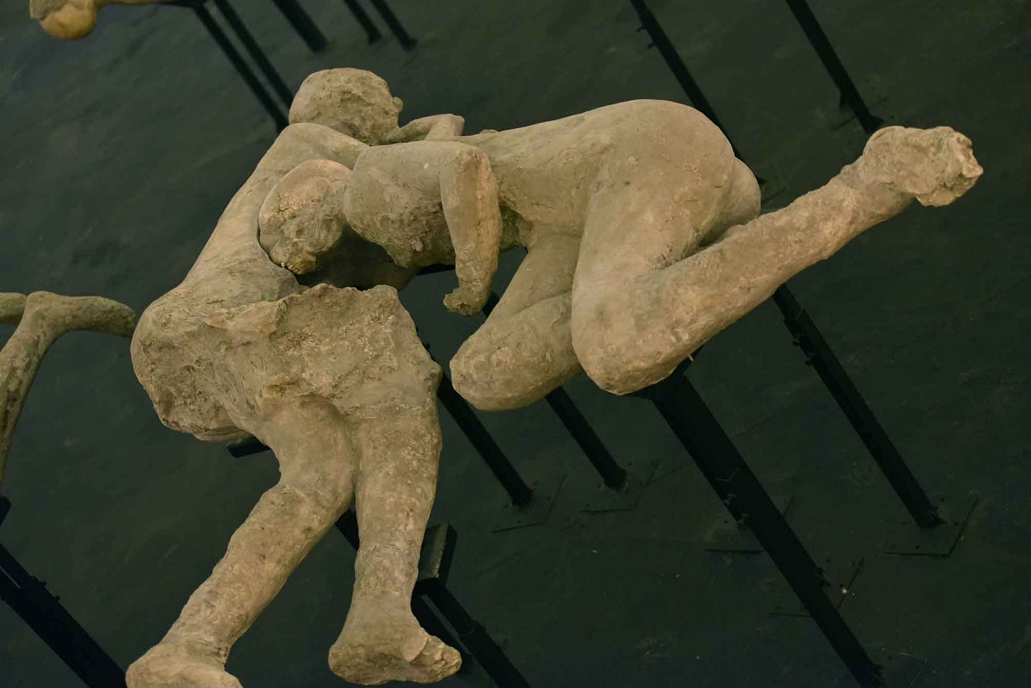 Two plaster casts of human bodies in contact with each other, supported above a black surface Two plaster casts of human bodies in contact with each other, supported above a black surface