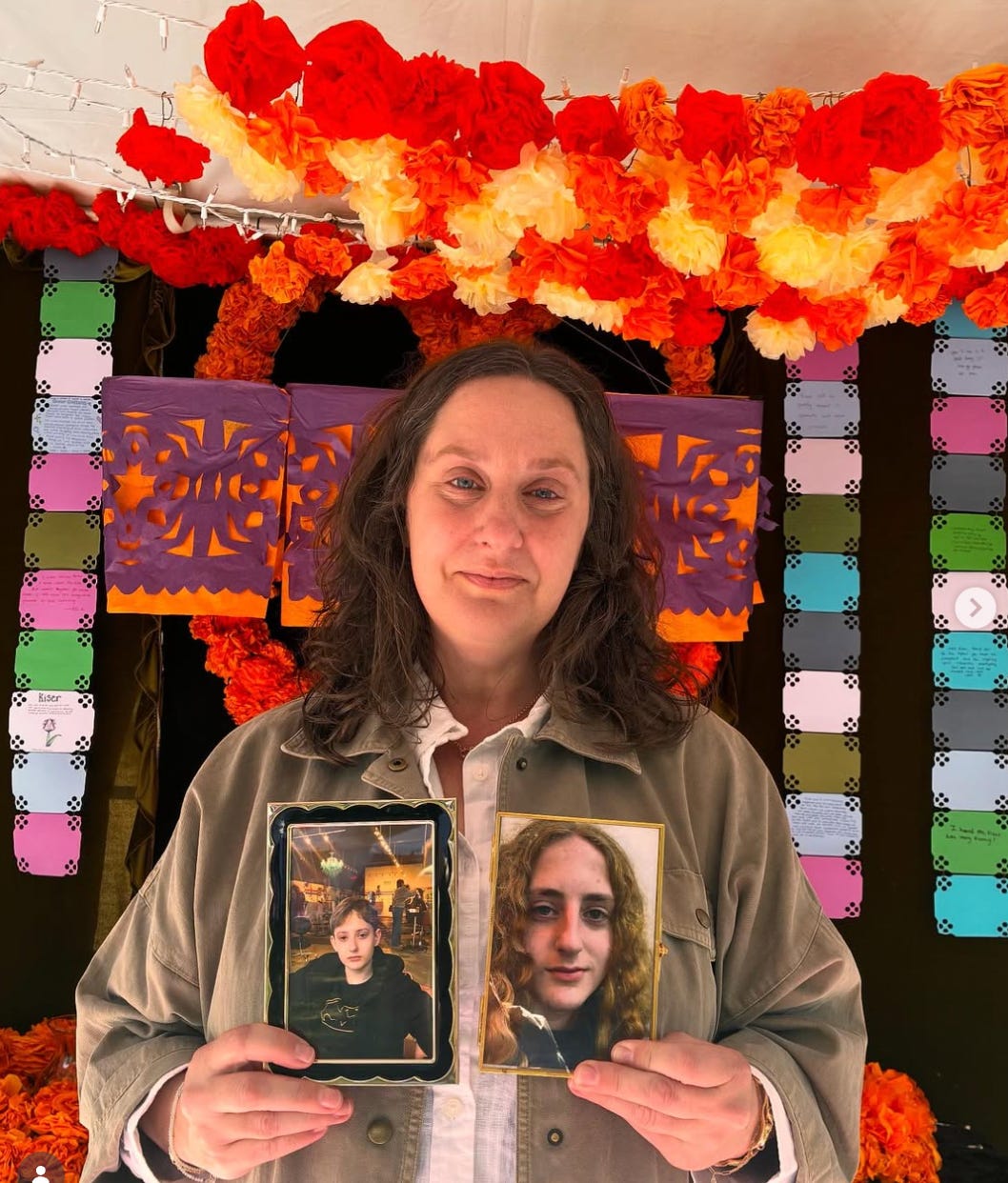 Kerrith MckDowell, a woman in a tan jacket is holding the photos of two boys