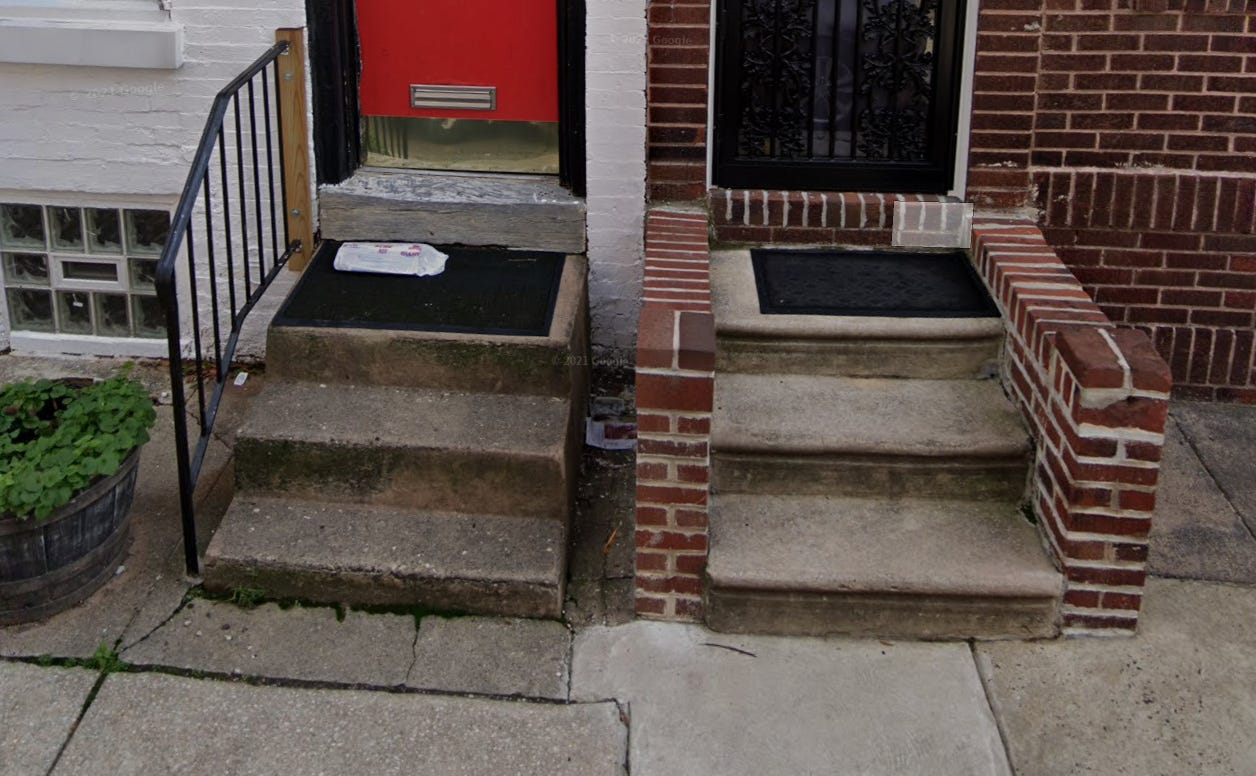 A picture of two South Philly homes' entryways, with several stairs leading up to the door.