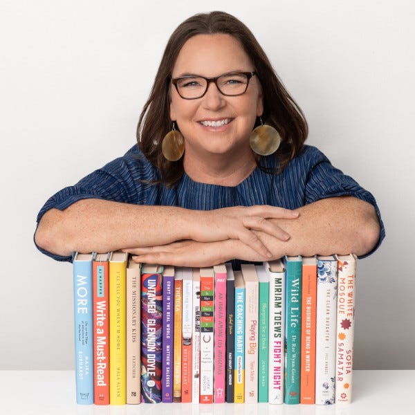 Bio photo of Esther Harder, leaning on stack of books.