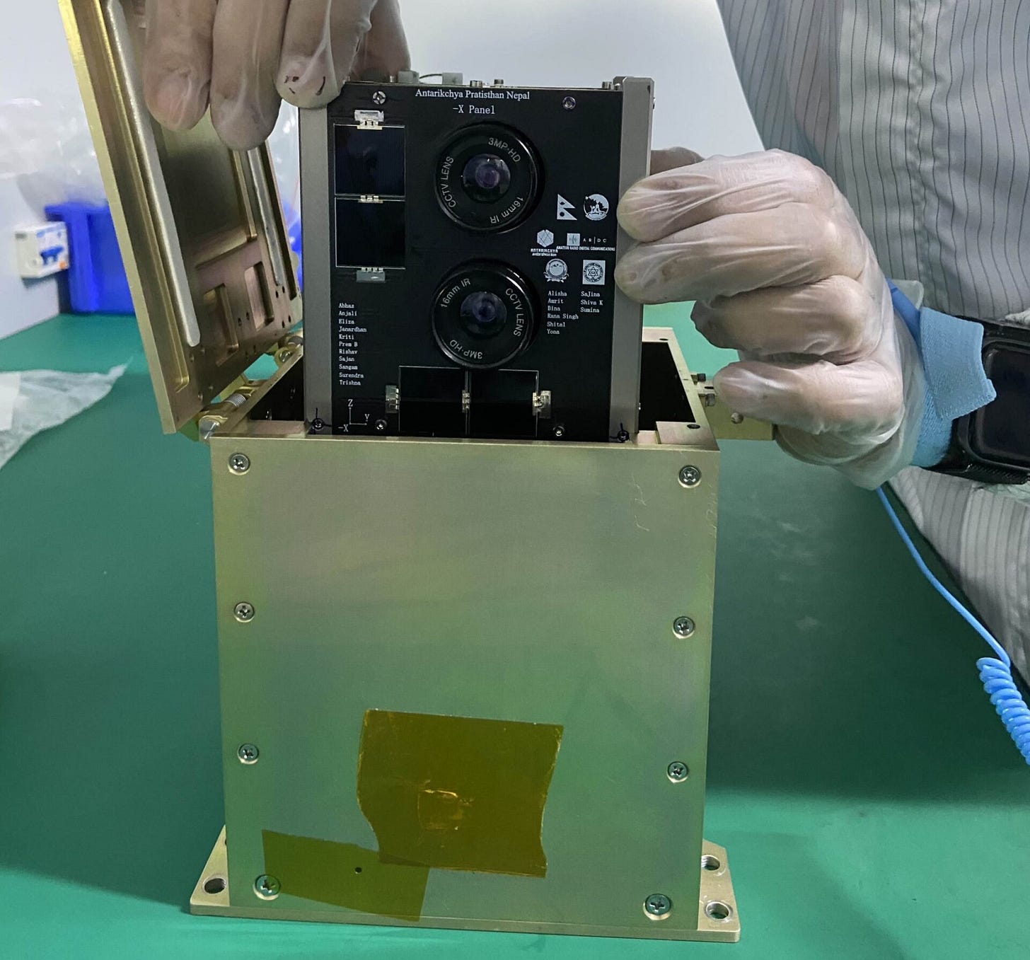 Nepal’s nanosatellite being placed into a deployment mechanism within a clean room. Nepal’s nanosatellite being placed into a deployment mechanism within a clean room.