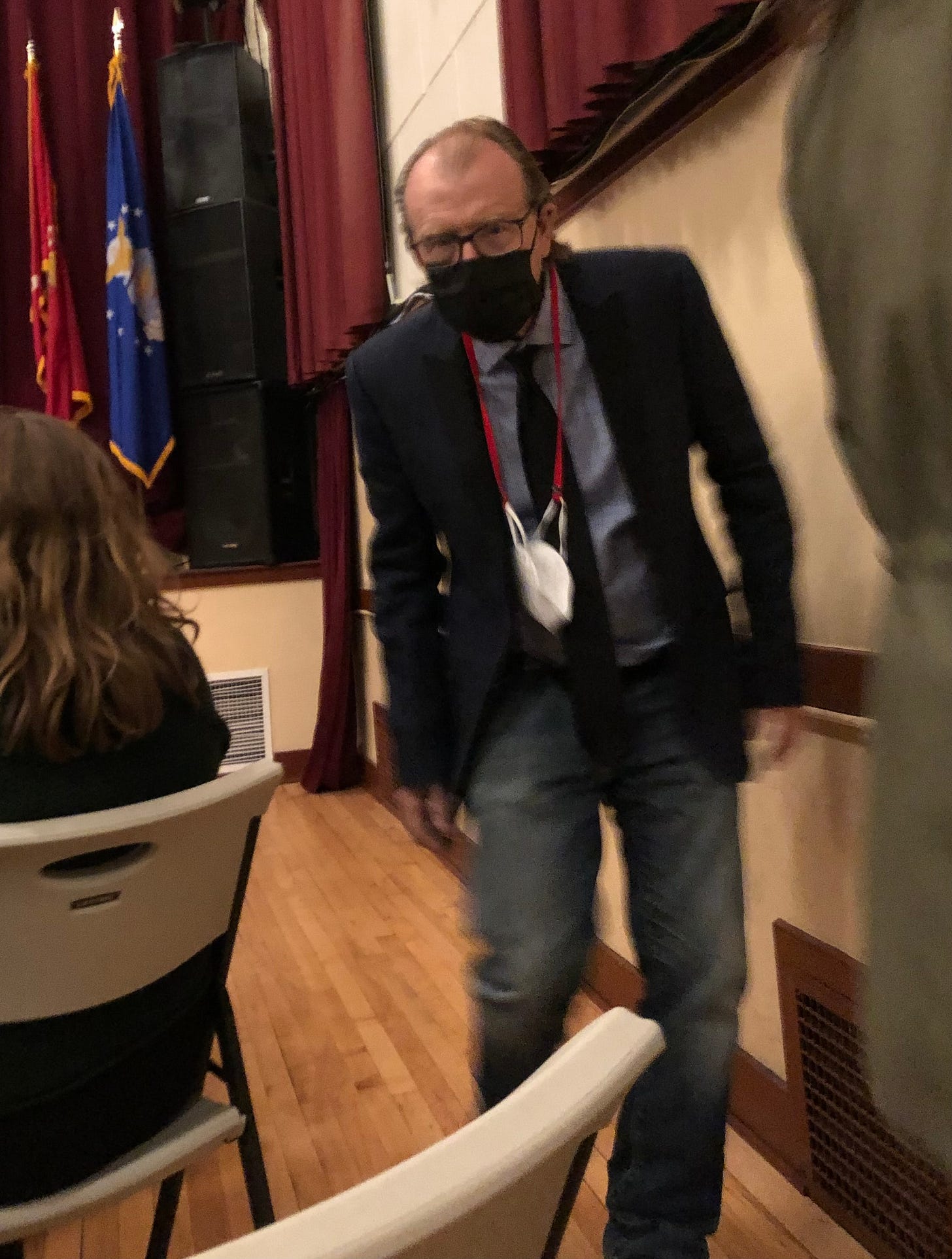 Author George Saunders wearing a mask and walking down the aisle of an auditorium Author George Saunders wearing a mask and walking down the aisle of an auditorium
