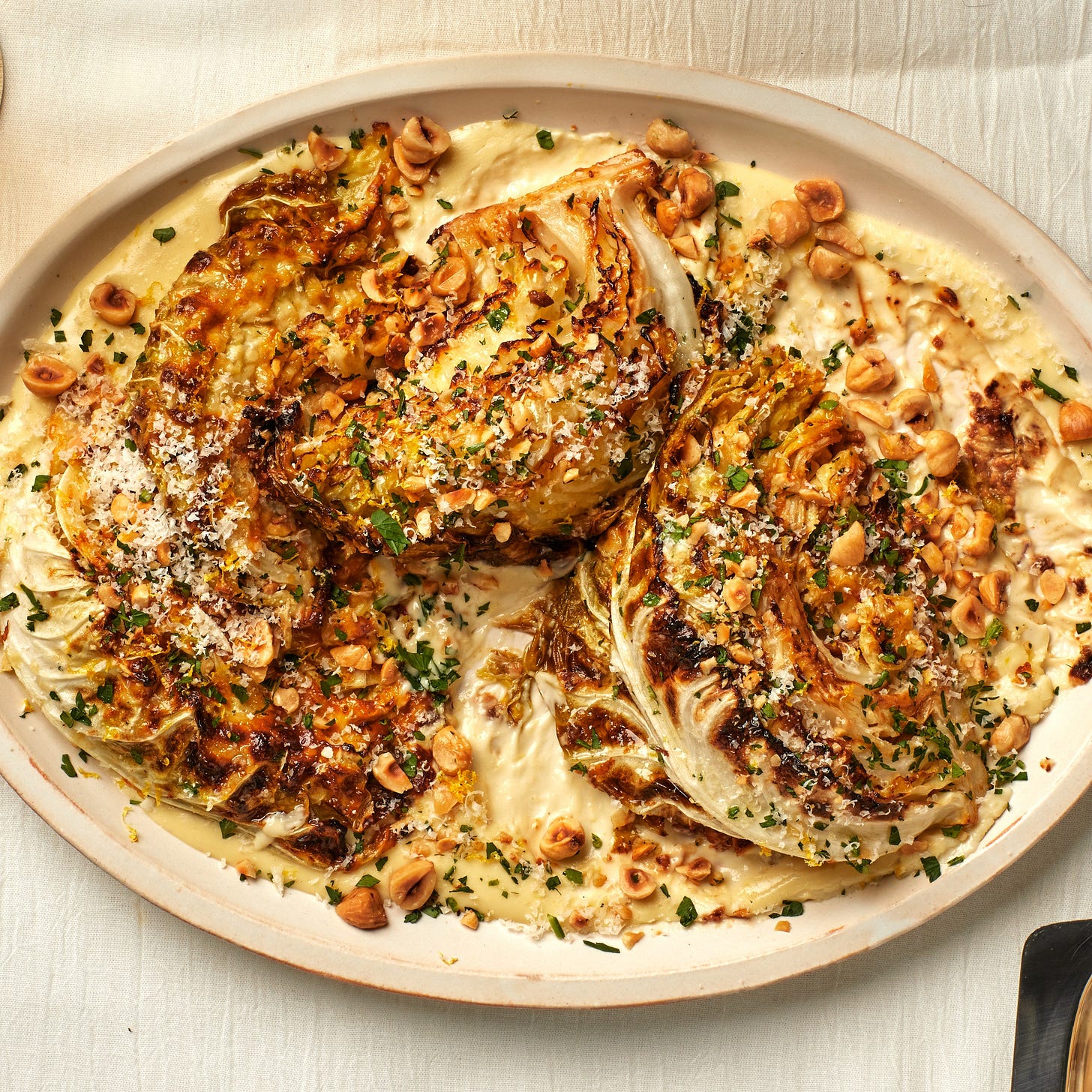Cheesy Roasted Cabbage Wedges on a cream plate placed on white fabric