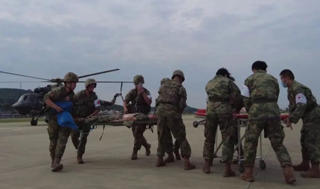 A group of soldiers carrying a stretcher

Description automatically generated