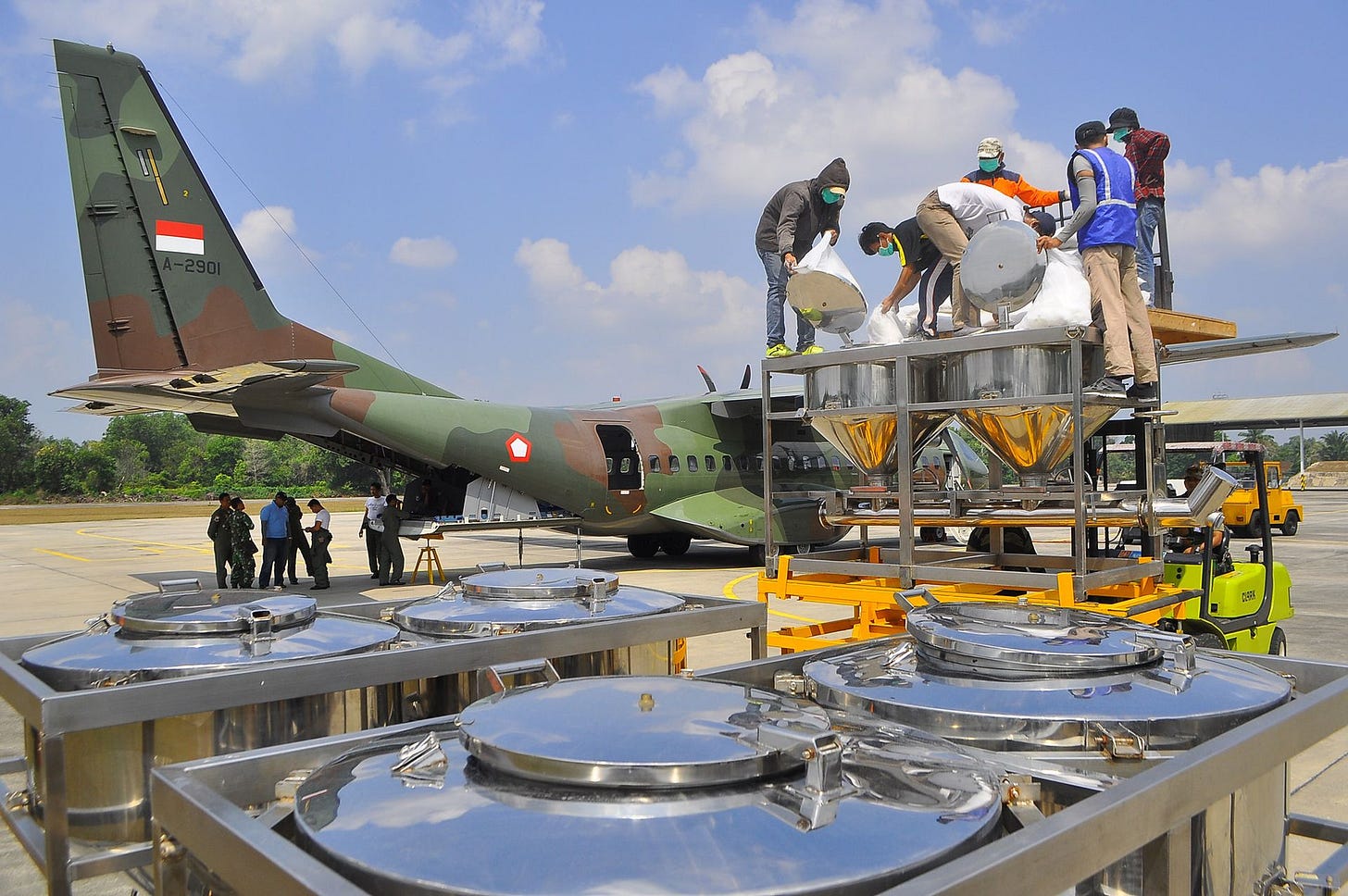 Indonesian officials loading chemicals for cloud seeding onto an air force plane at Roesmin Nurjadin air force base in Pekanbaru, Riau province, on July 3, 2015. Indonesian officials loading chemicals for cloud seeding onto an air force plane at Roesmin Nurjadin air force base in Pekanbaru, Riau province, on July 3, 2015.
