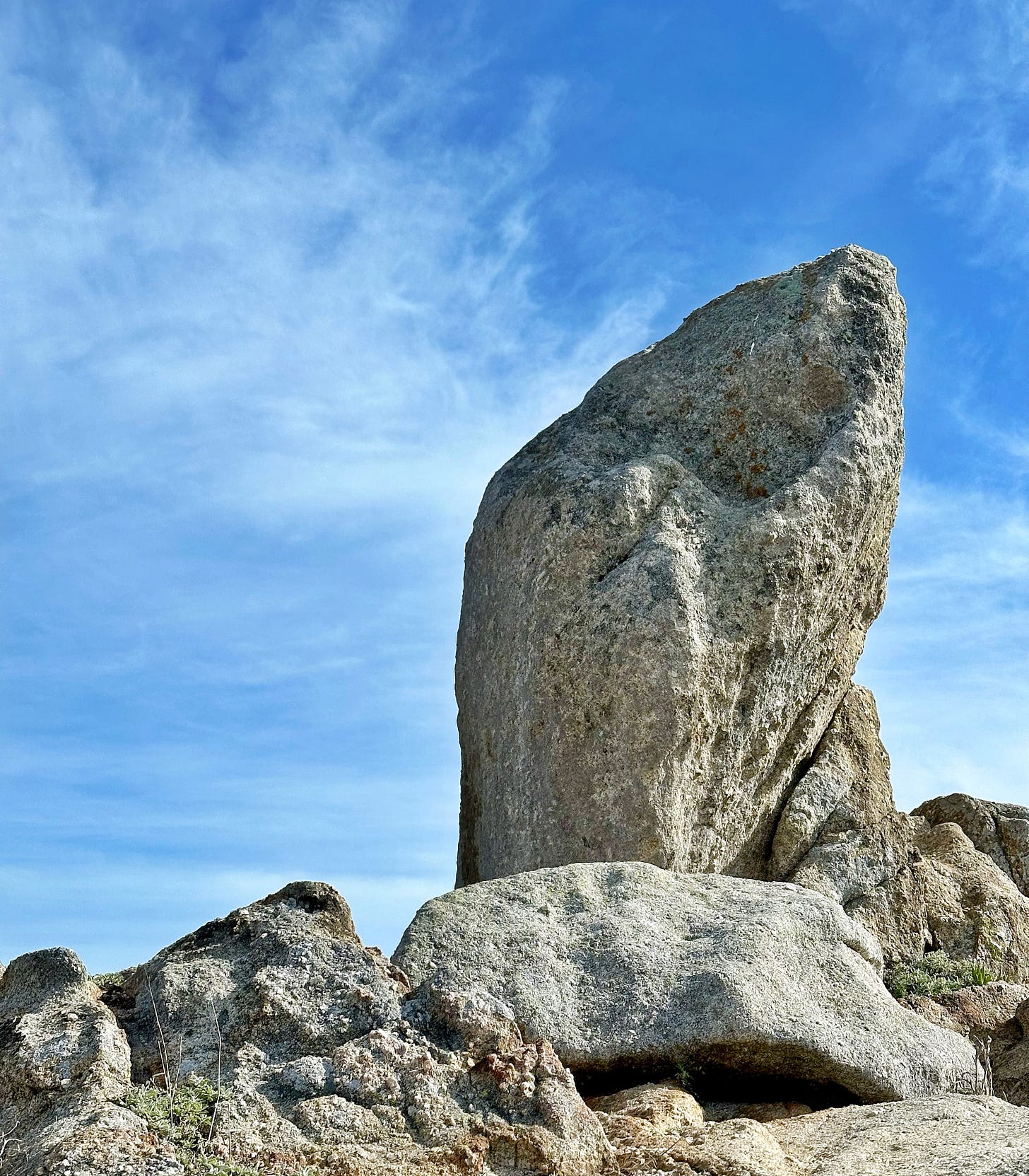 Giant rock at point lobos state park with a bright blue sky behind
