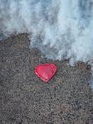 A heart shape on a beach with a wave coming in. A heart shape on a beach with a wave coming in.