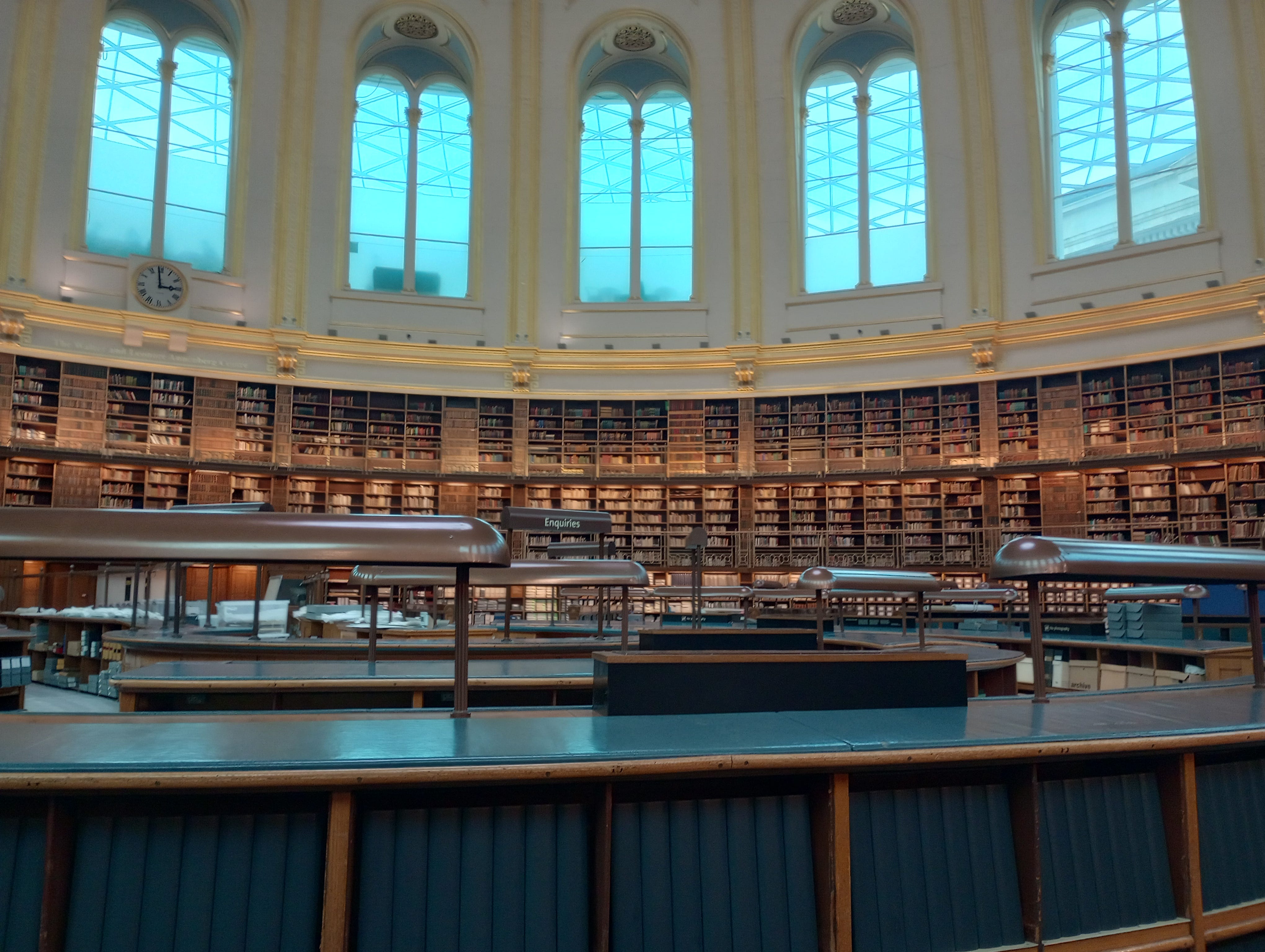 Massive round room with large high arched windows and books around the room, plus researchers' carrels at center Massive round room with large high arched windows and books around the room, plus researchers' carrels at center