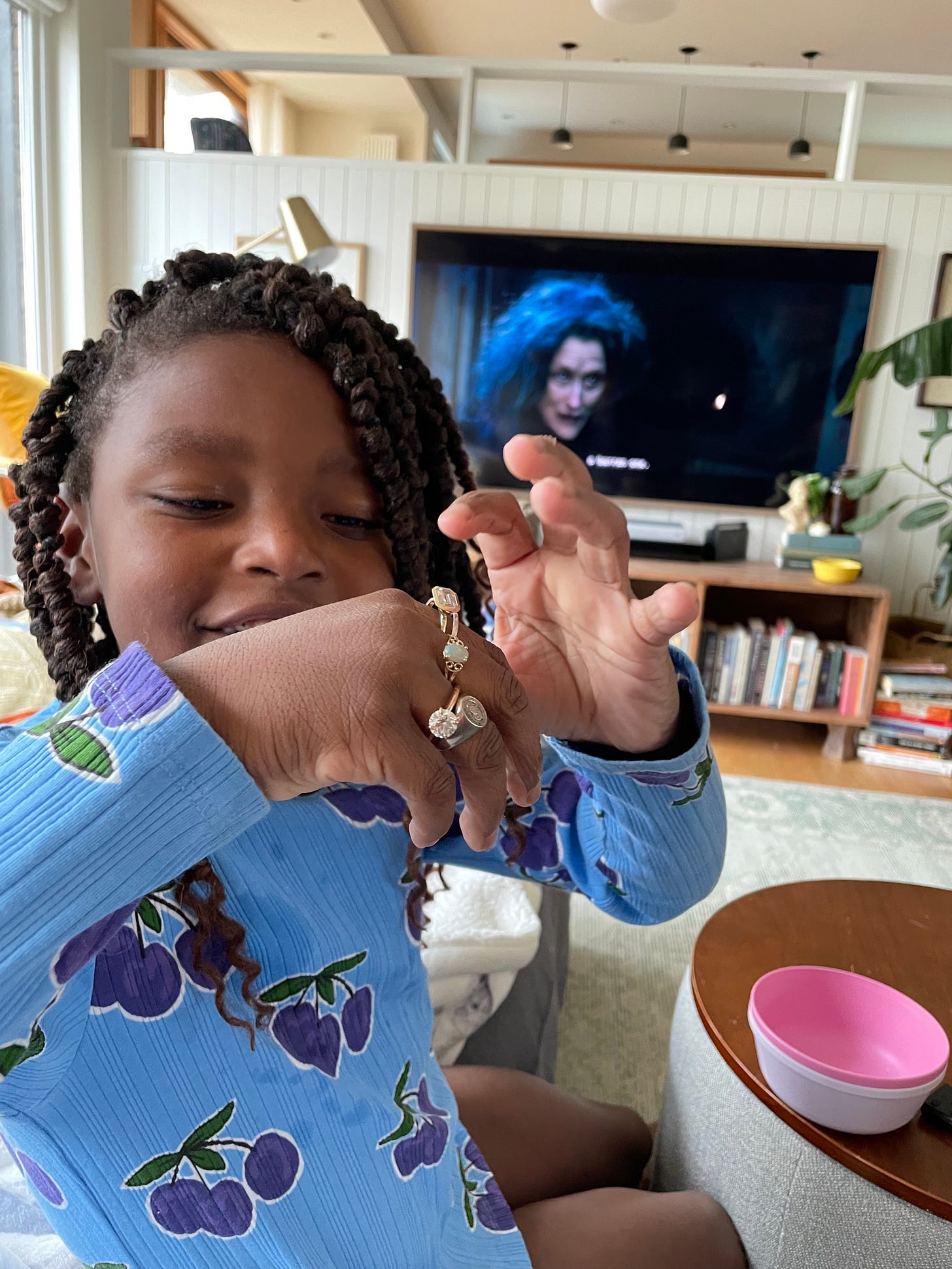 A Black child tries on a lot of rings