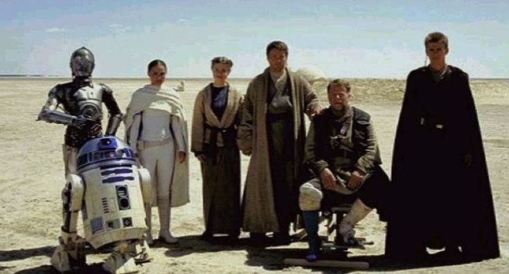 This may contain: a group of people standing next to each other in front of a star wars scene
