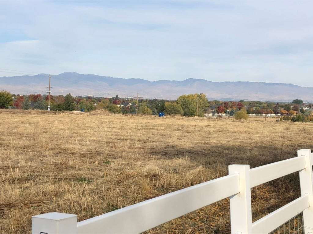 A field with a white fence

Description automatically generated
