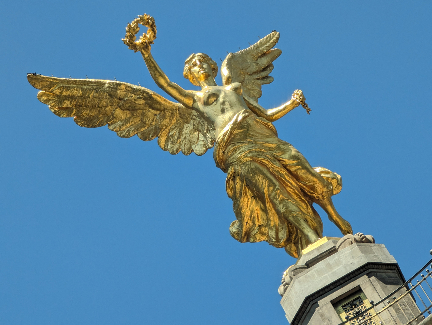 Golden angel statue against a blue sky