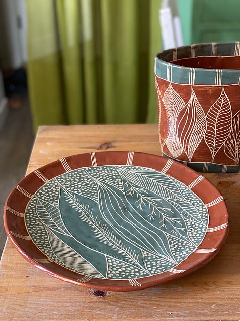 ceramic pieces decorated with a nature abstract design using slips and sgraffito: two platters, two flat panels and a vase
