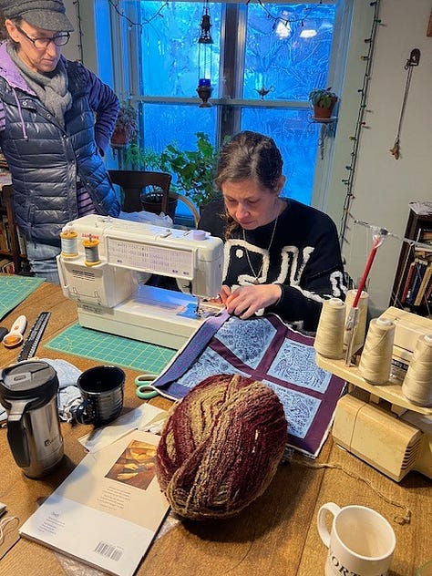 People sewing and spinning as they learn crafts.