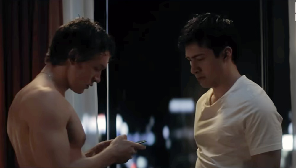 The two leads in Heated Rivalry in a hotwl room exchanging phone numbers